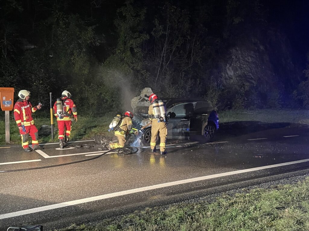 Feuerwehr Flims löscht Fahrzeugbrand Feuerwehrleute löschen Fahrzeugbrand in Trin GR